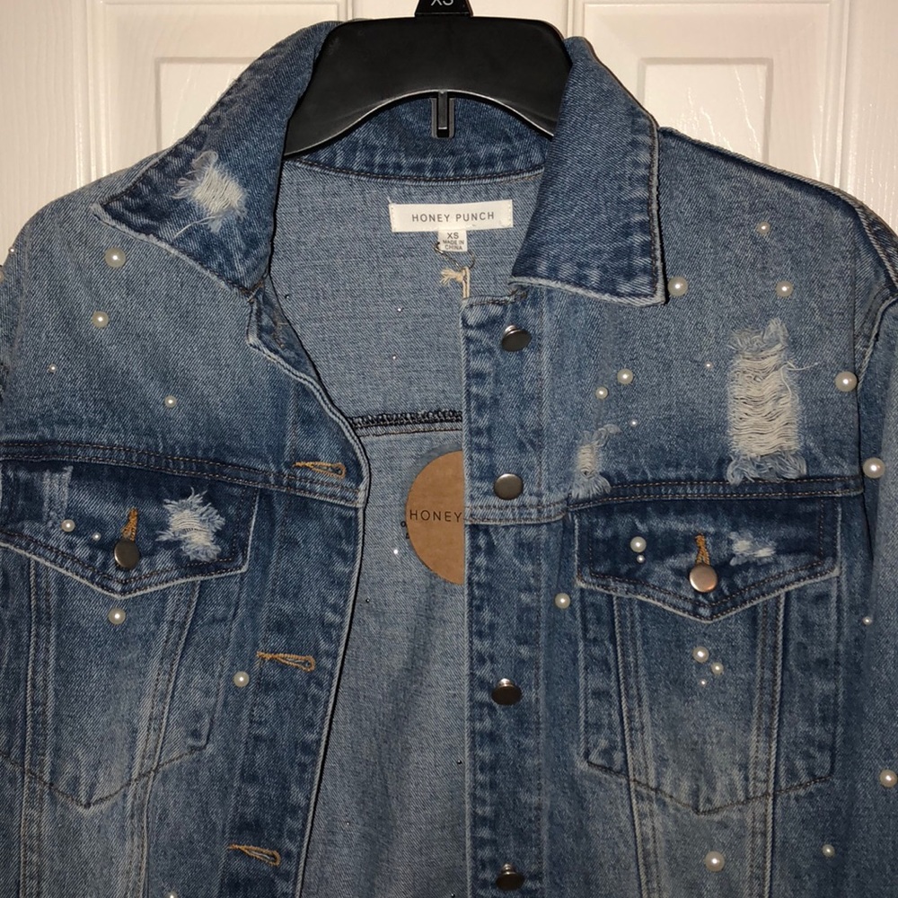 Denim Jacket with small pearls and a few rips.